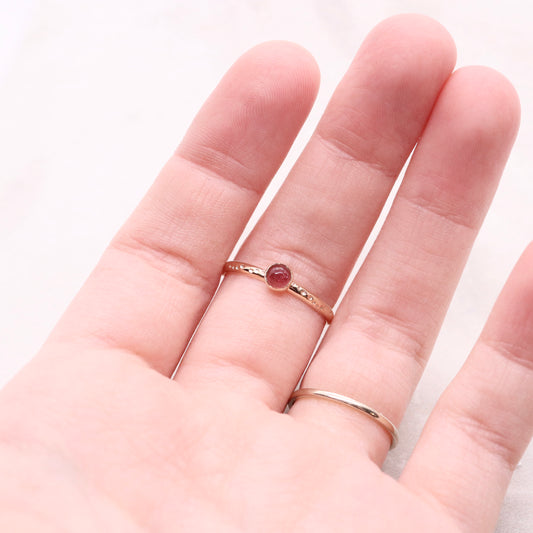 Pink tourmaline gemstone on a solid 14k gold ring band, a unique alternative engagement ring